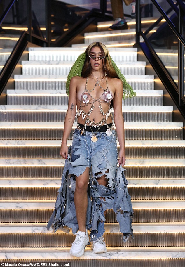 Strutting her stuff: The 21-year-old superstar offspring was showing off her perky assets in a bra-style top complete with chain adornments with just shells covering her modesty
