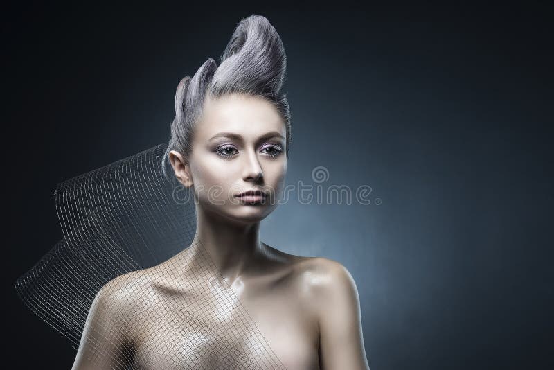 Conceptual portrait of beautiful naked shoulders vanguard hairstyle metallic colour hair girl wearing steel construction armature. Mesh. Copy space. Building stock images